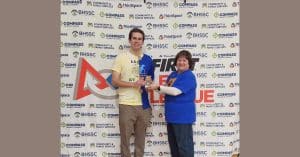 Coach/Mentor of the Year, Isaac Haar, stands holding award with 168全国统一开奖网极速赛车结果记录体彩历史查询网 Learning Specialist, Billie Jo Bakeberg
